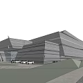 Modern Museum Building With Geometric Structure Glass Facade And Waterfront Grassy Area Under Cloudy Sky