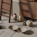 Ceramic Vases And Bowls With Natural Texture On Tile Floor Near Wooden Cabinet
