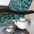 Green Patterned Armchair With Black Armrests And Side Table With Teapot Cups 3d model