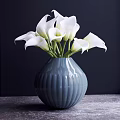 Blue Ceramic Vase With Vertical Stripes Holding White Calla Lilies On Wooden Surface