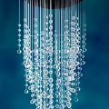 Elegant Crystal Chandelier with Layered Dangling Glass Beads Against Blue Background