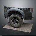 Black Pickup Truck Rear View With Large Off-Road Tires Silver Fender Flares On Brick Pavement