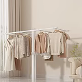 Living Room with White Clothes Rack Various Clothes Beige Sofa Curtains and Green Plant