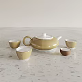 Beige Ceramic Tea Set With Teapot And Matching Cups On White Countertop