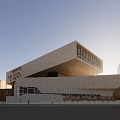 Modern Building Exterior Design With Light Colored Facade Surrounding Trees And Blue Sky