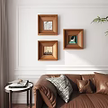 Portrait Paintings In Wooden Frames Hanging On Living Room White Wall With Leather Sofa