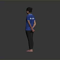 Woman Standing Barefoot In Blue Polo Shirt And Black Pants Against Gray Background