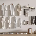 Soft White Robes Hanging On Wall With Towel Racks And Toiletries