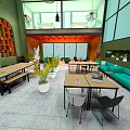 Modern Cafe Interior With Green Walls Orange Accents Long Tables Sofa Seating And Hanging Lights