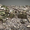 Rugged Rocky Terrain With Scattered Pebbles Green Vegetation Wooden Stakes And Chain