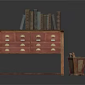 Wooden Drawer Cabinet With Metal Handles Old Books On Top And Metal Trash Bin Beside