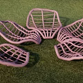 Purple Mesh Outdoor Chairs With Curved Wave Design On Green Grass