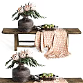 Rustic Ceramic Vase With Protea Flowers On Wooden Bench With Patterned Cloth And Fruit Plate