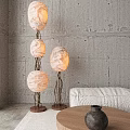 Abstract Floor Lamp With Three White Shades Black Metal Stand Gray Concrete Wall Mountain View