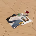 Open Magazine Displaying Colorful Images with Red Wine Glass Green Pen on Wooden Floor
