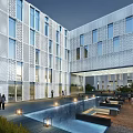 Modern Office Building Exterior With Glass Curtain Wall And Water Pool At Night