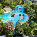 Vibrant Children's Play Area With Colorful Slide Swing And Lush Green Trees