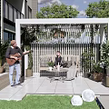 White Outdoor Pergola With Green Plants Outdoor Seating And Relaxation Area Next To House Lawn