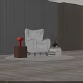 Red Table Lamp on Brown Cube Base Beside Gray Furry Armchair and Stack of Books