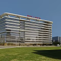Modern Pediatric Hospital Building With Glass Curtain Walls And Green Lawn Under Blue Sky