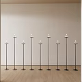 Nine Black Candle Lamps Neatly Arranged In Room With Light Colored Wall And Wooden Floor