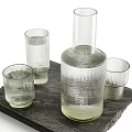 Transparent Ribbed Glasses with Macarons Lit Candle and Glass Bottle on Slate Tray