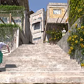 Traditional Multi Story Old Buildings With Climbing Plants Stone Steps And Purple Flowers Area