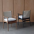 Modern Minimalist Dining Chairs With Wooden Frames Woven Backrests And Seat Cushions Against Wooden Wall