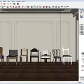Various Styles of Dining Chairs Against Light Colored Walls With Decorative Moldings and Wooden Flooring