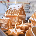 Decorated Gingerbread Houses And Cookies On Wooden Tray With Icing And Snowflake Designs
