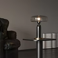 Modern Table Lamp with Transparent Lampshade and Metal Base Near Leather Sofa and Open Book