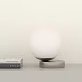 Modern White Globe Table Lamp With Silver Base On White Tabletop And Books 3d model