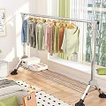 Metal Clothes Rack Hanging Various Colored Clothes With Storage Box On Wooden Bedroom Floor