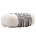 Cozy Beige Ottoman With Soft Gray Blanket Draped On Top