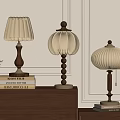 Three Elegant Table Lamps On Wooden Cabinet With Books And Green Plant