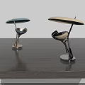 Two Stylish Modern Table Lamps with Metal Bases and Colored Shades on Wooden Table
