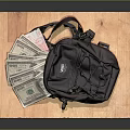 Black Canvas Small Backpack With US Dollar Bills On Wooden Platform 3d model