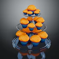 Three Tiered Transparent Glass Cupcake Stand Holding Multiple Orange Cupcakes