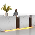 Elegant Marble Reception Desk with Wooden Accents Yellow Lighting Vase Plant and Person Sitting