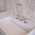 White Bathroom Vanity With Countertop Faucet Knobs Drawers And Patterned Tiled Wall