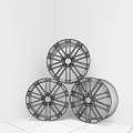 Three Silver And Blue Wheel Rims Leaning Against Brick Wall Corner On Gray Tiled Floor