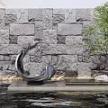 Flowing Metal Sculpture With Curved Design By Stone Wall Water And Tree