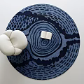 Deep Blue Round Rug With Concentric Circles Design Featuring Open Book And White Cushioned Seat