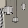 Three Modern Cylindrical Fabric Pendant Lights Hanging from Ceiling in Bright Indoor Space