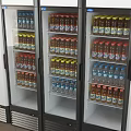 Organized Refrigerator Interior with Neatly Arranged Bottled Drinks on Shelves and Colorful Caps