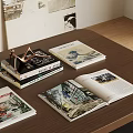 Stacked Books And Magazines On Wooden Table With Open Illustrated Book And Metal Decor