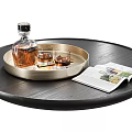 Whiskey Bottle and Glasses on Gold Round Tray with Open Magazine on Black Table