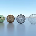 Intricate Hollow Spherical Sculpture Carvings In Four Colors Against Light Blue Sky And Light Ground