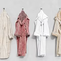 Four Soft Hooded Terry Robes In Different Colors Hanging On Wall Hooks