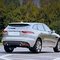 Silver Jaguar SUV Parked On Outdoor Lot With Trees